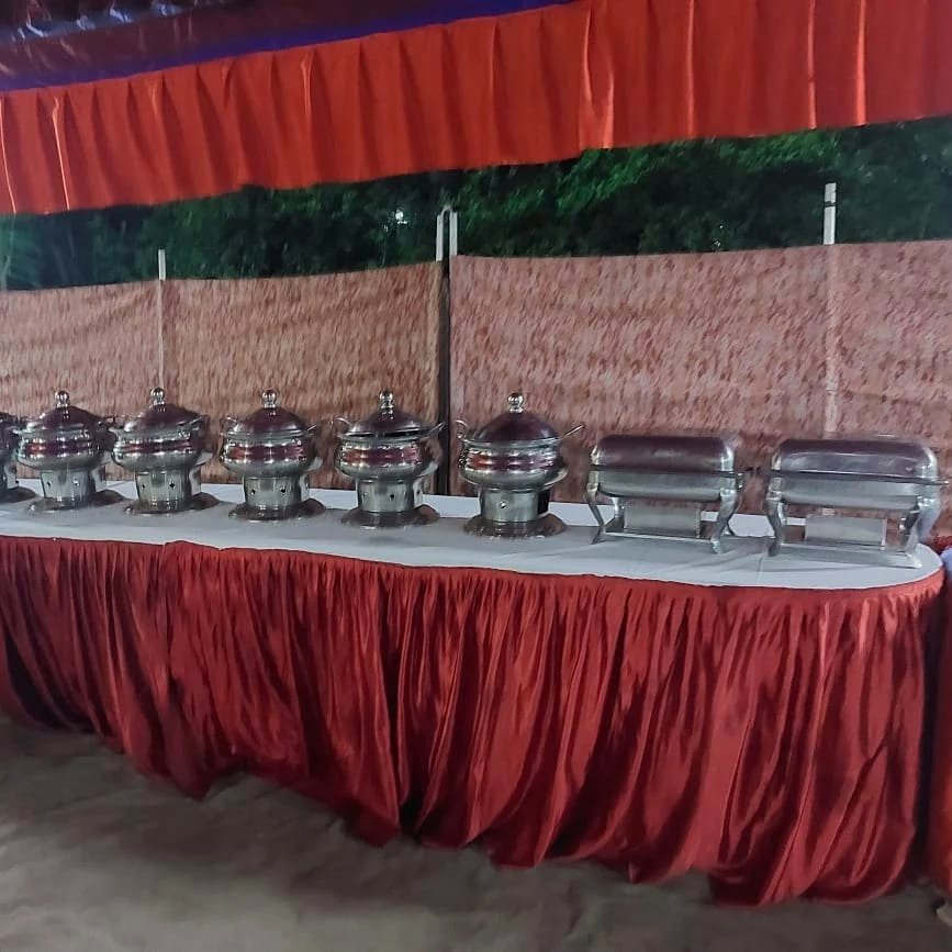 Row of chafing dishes set up on a skirted buffet table