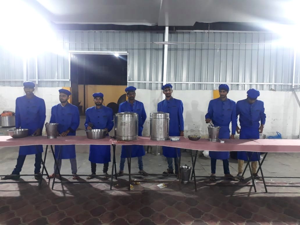 Catering staff lined up ready to serve at a live counter